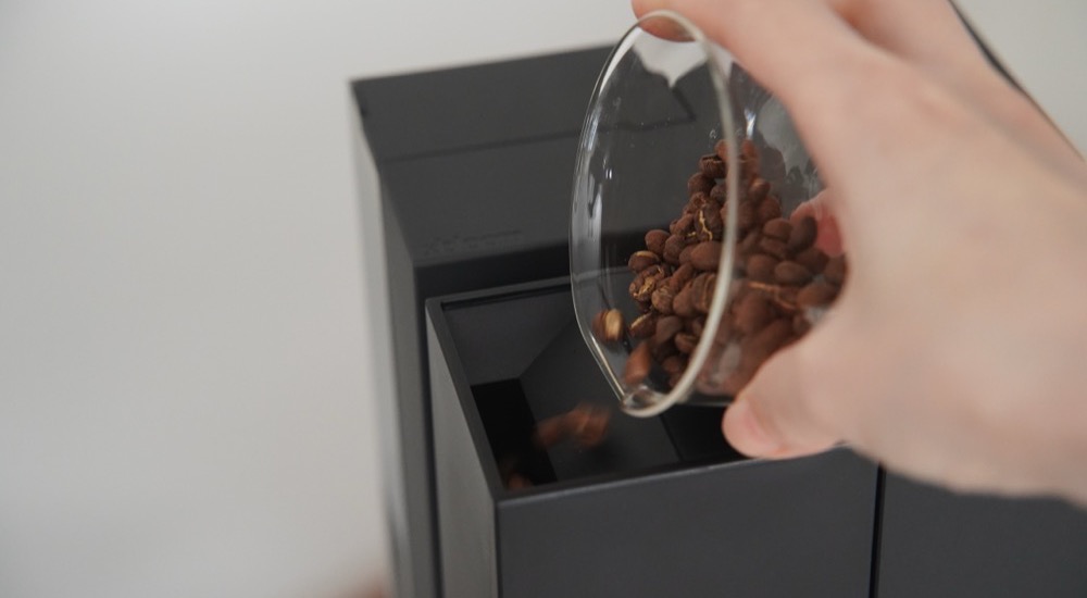 コーヒー豆をグラインダーにいれる
